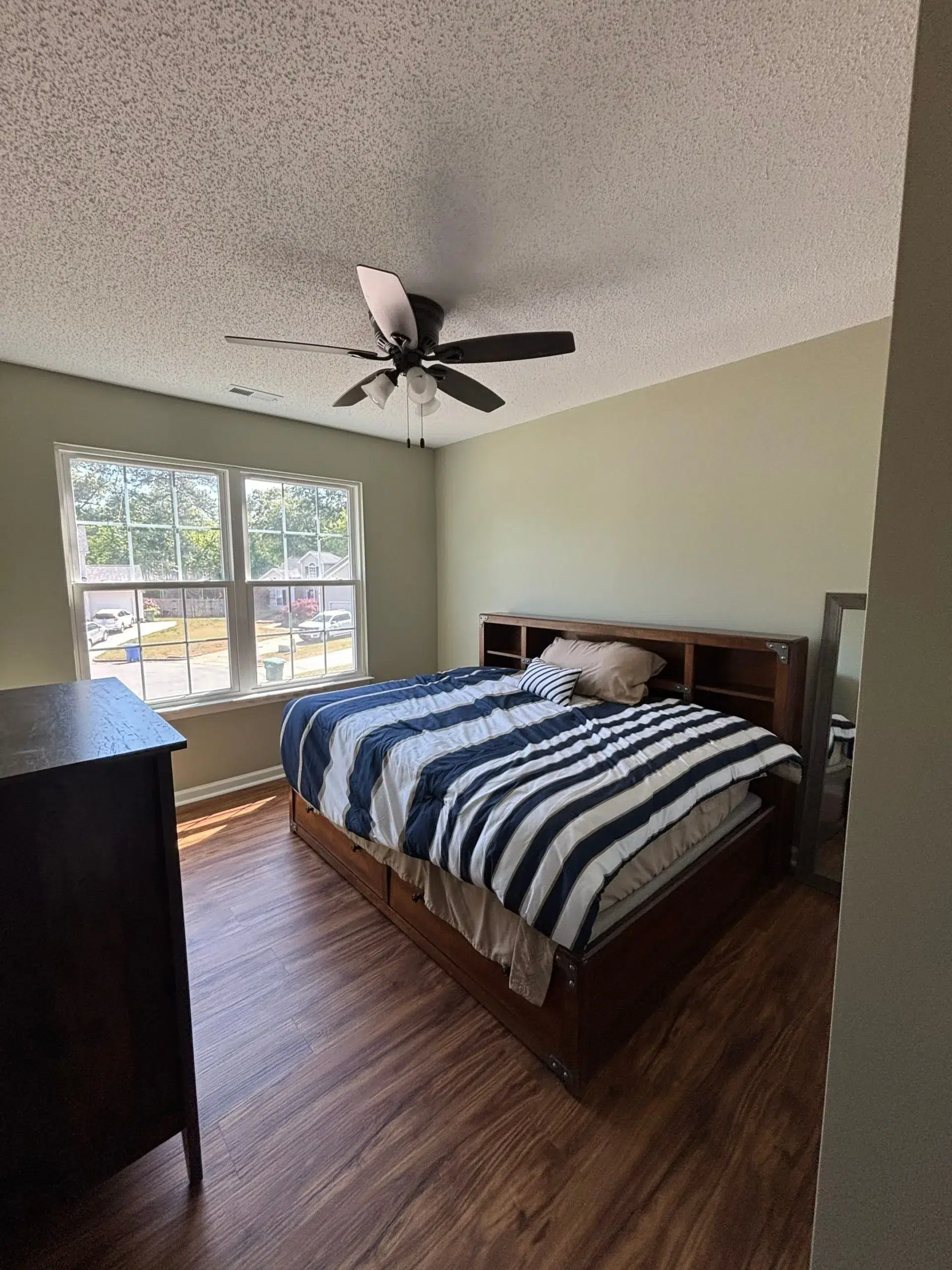 Modern Bedroom Interior Painting with Neutral Wall Colors Freshly painted bedroom interior with warm neutral walls, a large window, and a wooden bed.
