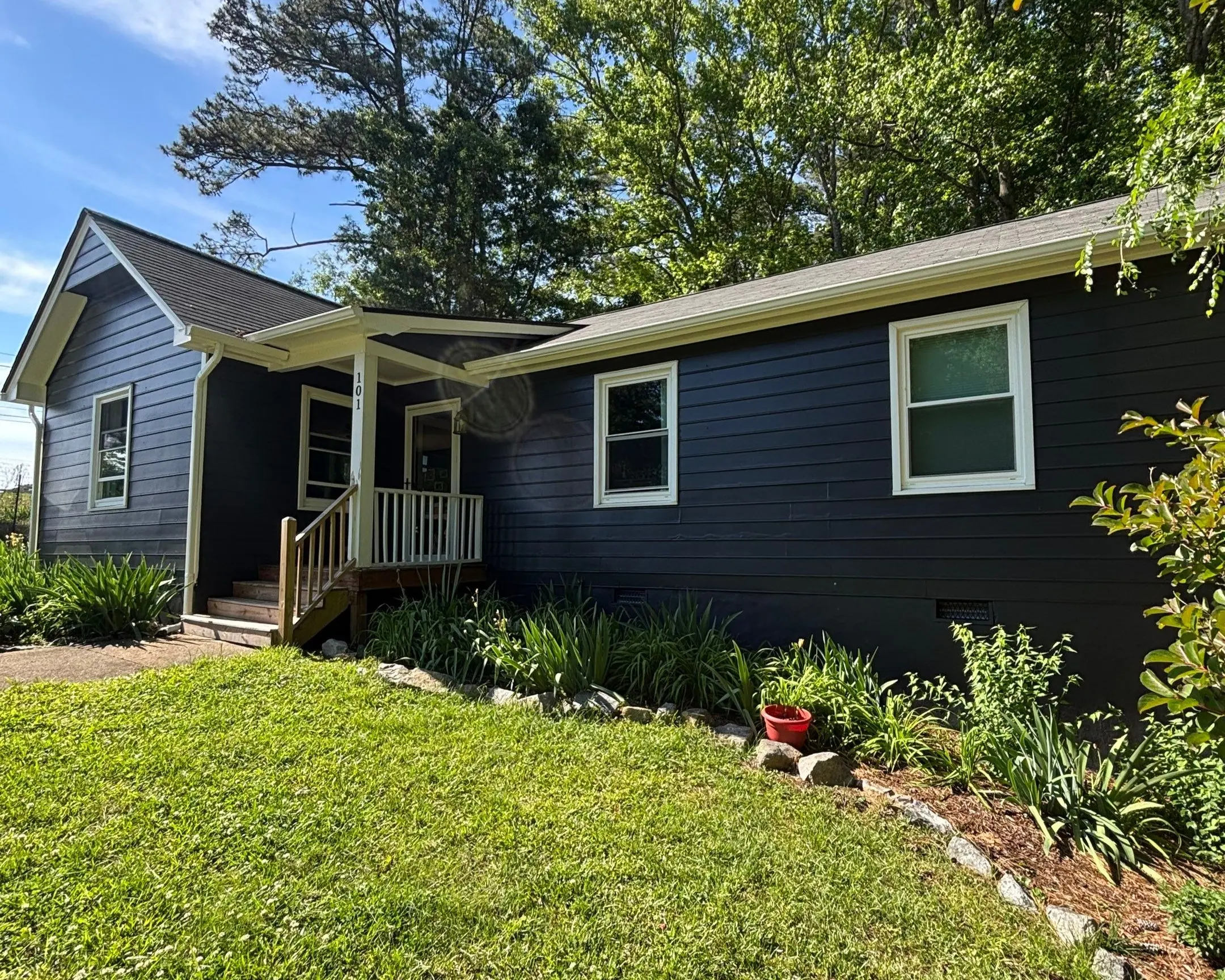 Exterior House Painting Dark Blue Siding White Trim A modern home with freshly painted dark blue siding and crisp white trim.